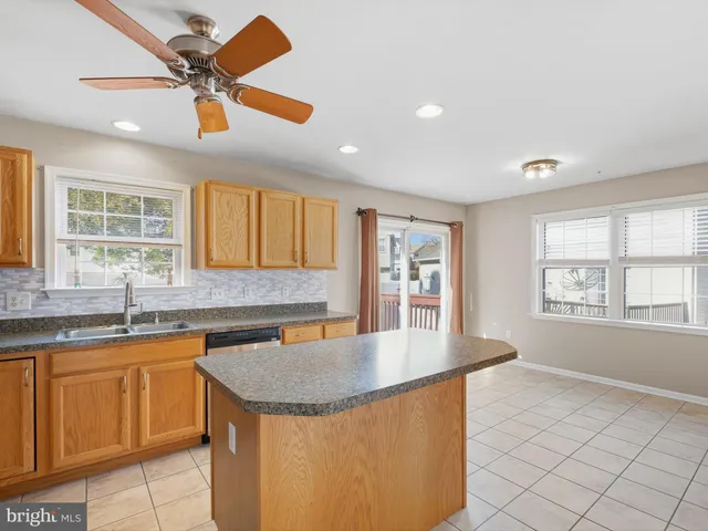 a kitchen with granite countertop a sink a window and cabinets