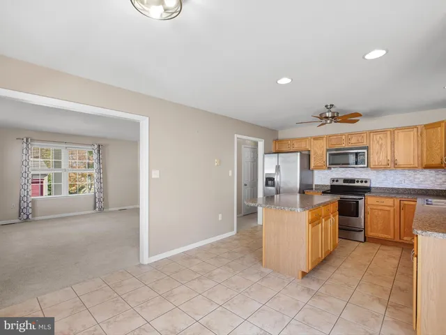 a large white kitchen with a stove a sink dishwasher and a refrigerator