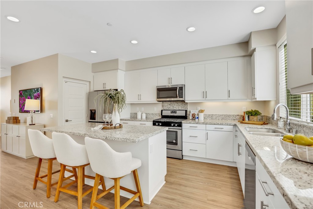 181 Magnet Irvine, CA 92618 - Photo 23 of 45 a kitchen with stainless steel appliances granite countertop a stove top oven a sink dishwasher and white cabinets with wooden floor