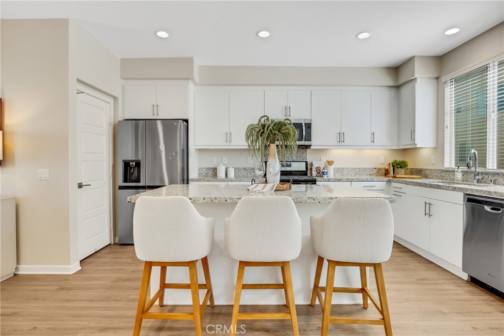 181 Magnet Irvine, CA 92618 - Photo 24 of 45 a white kitchen with stainless steel appliances granite countertop a dining table chairs and a refrigerator