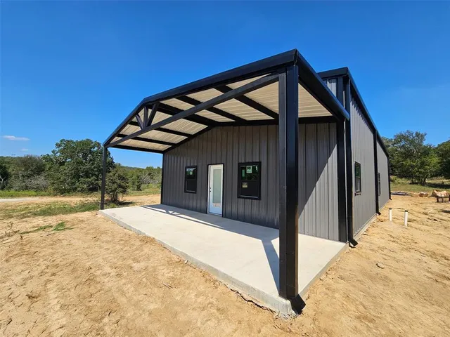 a view of a house with backyard and trees