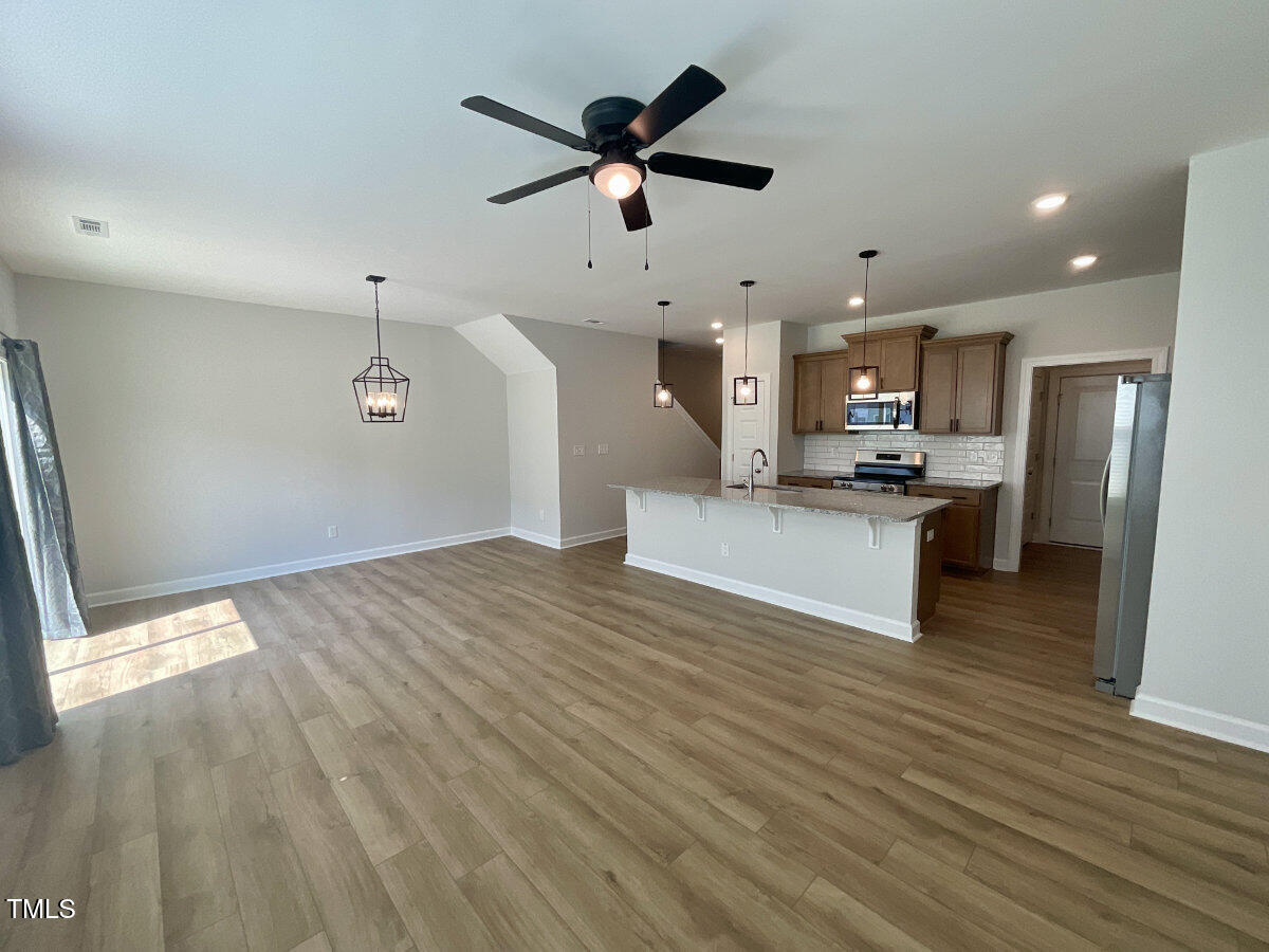 166 Nimble Way Clayton, NC 27520 - Photo 11 of 40 a view of empty room with wooden floor and ceiling window
