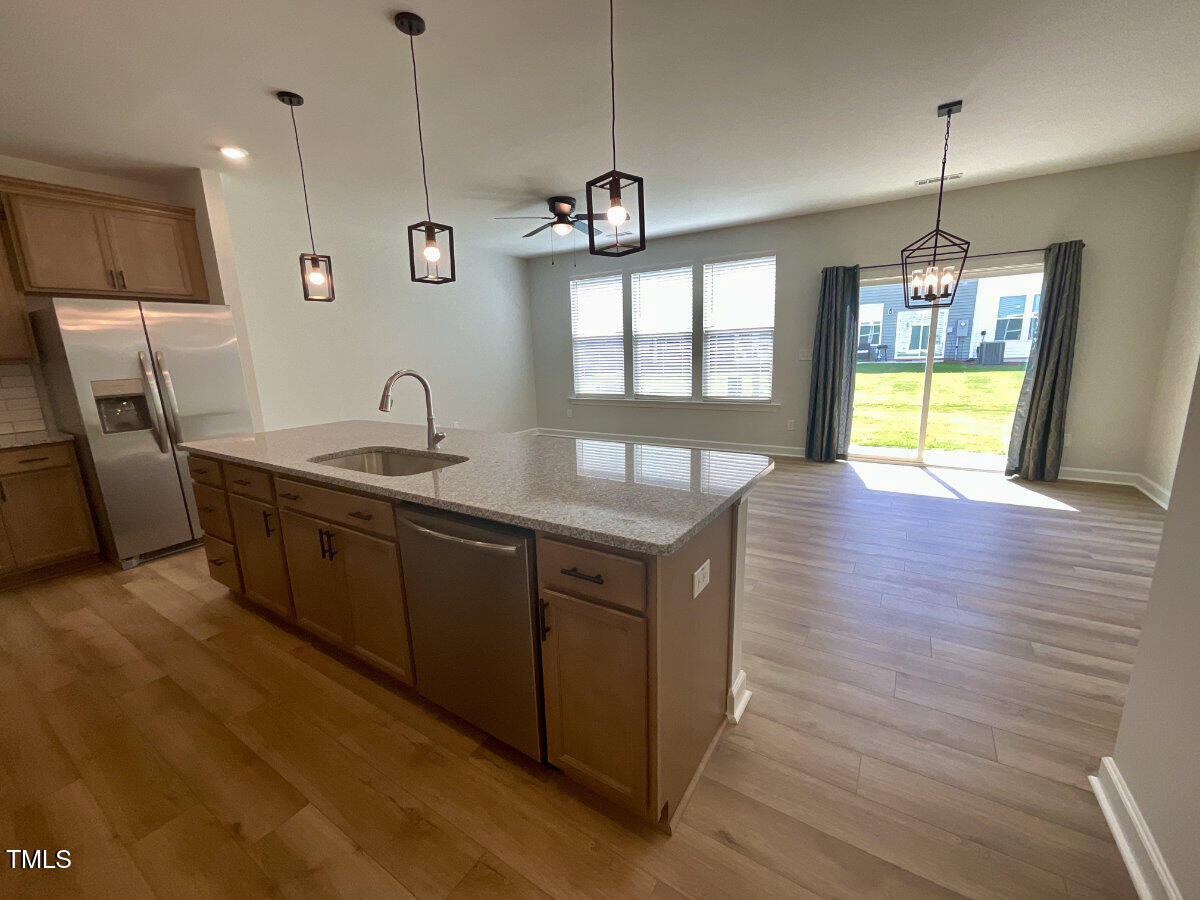 166 Nimble Way Clayton, NC 27520 - Photo 3 of 40 a large kitchen with stainless steel appliances granite countertop a sink a oven and a wooden floors