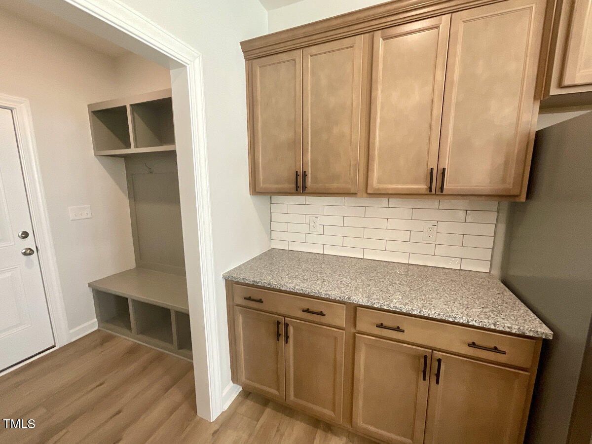 166 Nimble Way Clayton, NC 27520 - Photo 10 of 40 a kitchen with granite countertop cabinets and wooden floor
