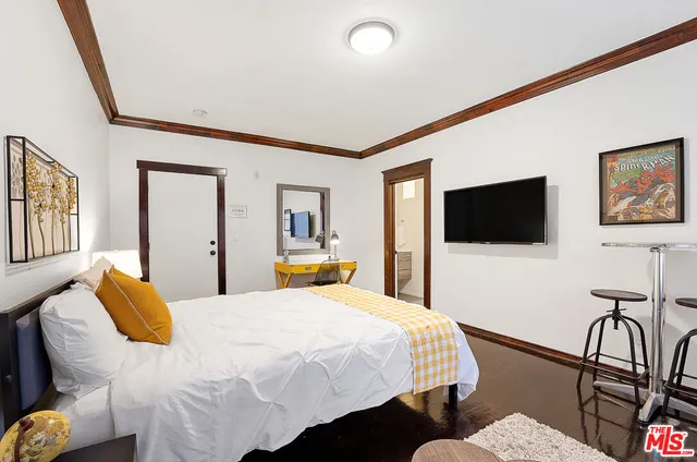 a bedroom with a bed and a flat screen tv