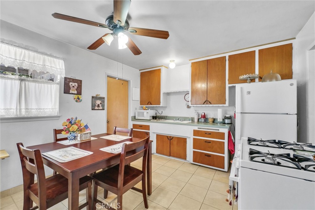 2551 Rome Avenue Anaheim, CA 92804 - Photo 8 of 27 a kitchen with stainless steel appliances granite countertop a stove refrigerator a sink dishwasher with a dining table and chairs