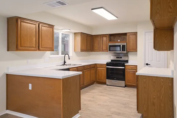 a kitchen with stainless steel appliances granite countertop a sink stove and refrigerator