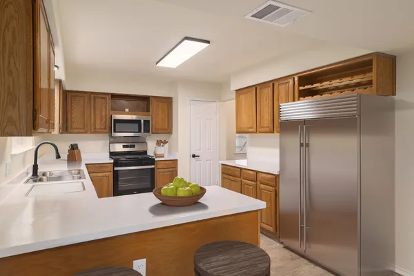 a kitchen with stainless steel appliances granite countertop a sink refrigerator and microwave