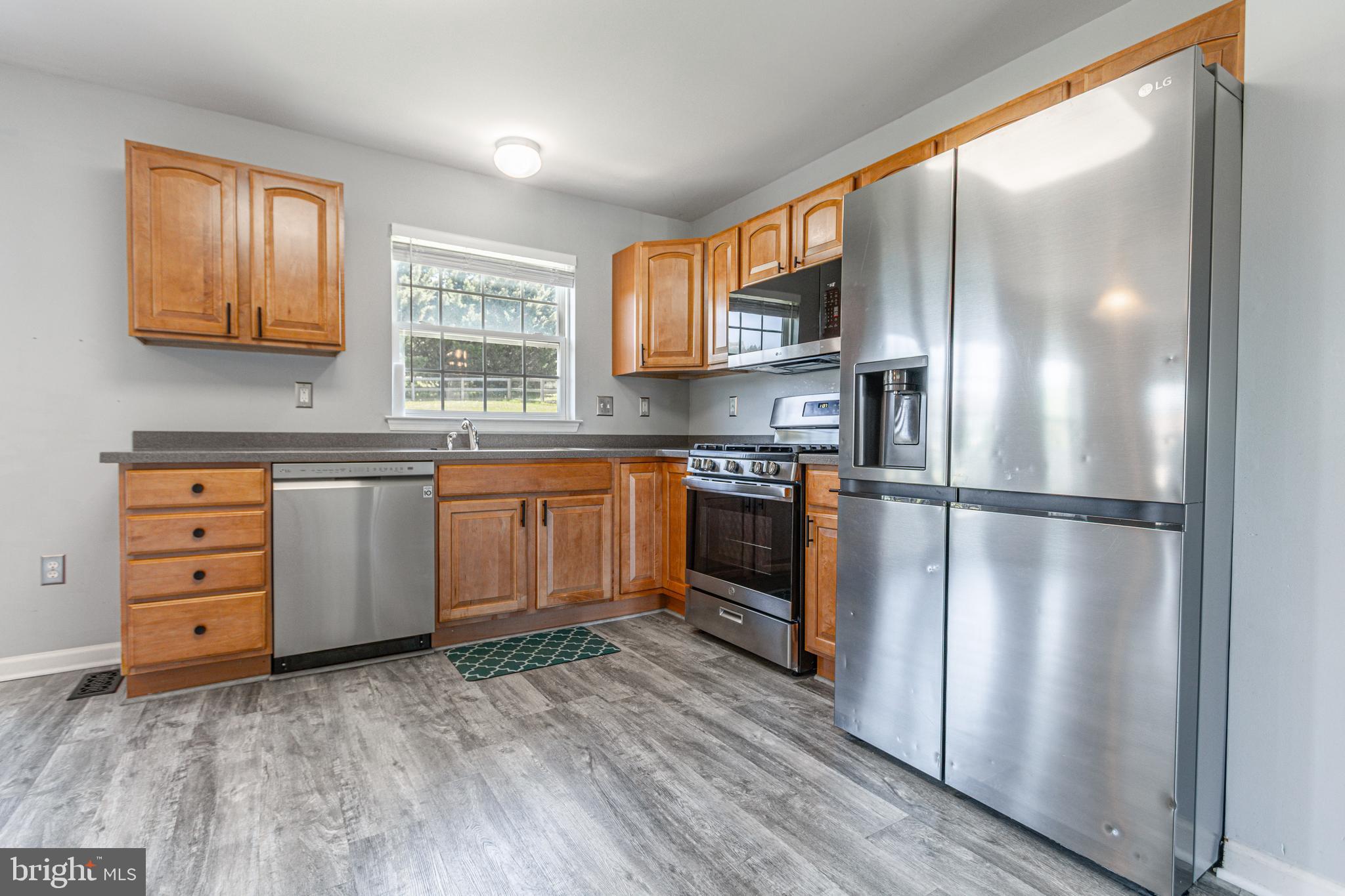 271 Courtney Court Spring Grove, PA 17362 - Photo 17 of 51 a kitchen with stainless steel appliances granite countertop a refrigerator a sink dishwasher a stove with wooden cabinets and floors