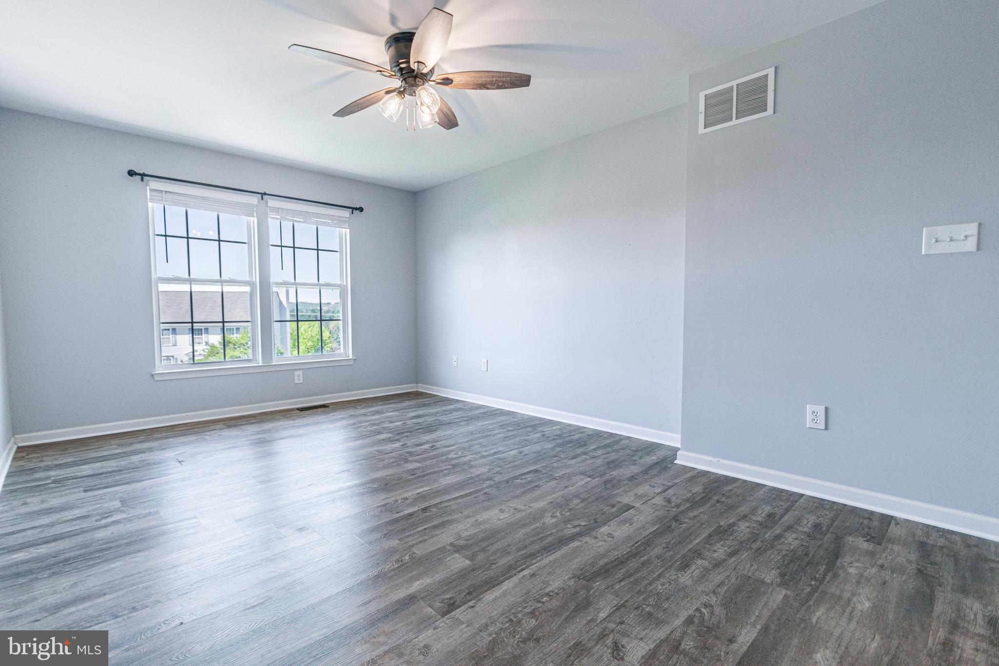 271 Courtney Court Spring Grove, PA 17362 - Photo 40 of 51 an empty room with wooden floor ceiling fan and windows