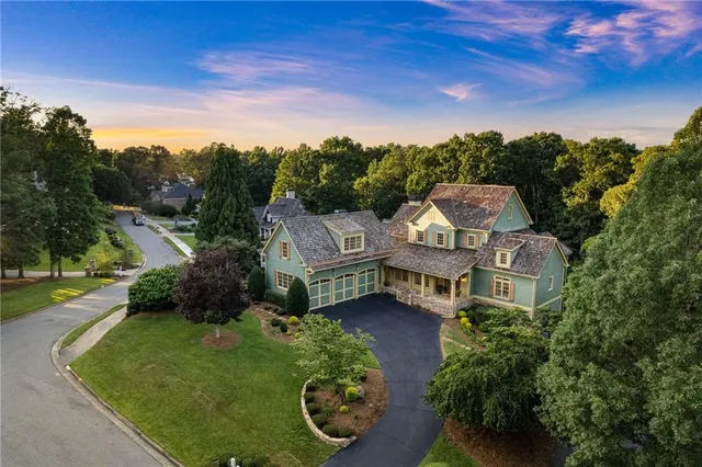 an aerial view of a house with a yard and lake view