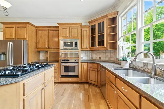 an empty room with windows fireplace and a ceiling fan