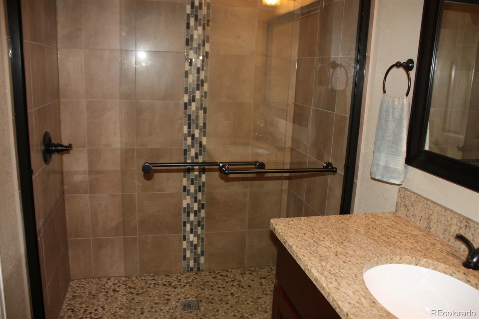 1078 Clark Road Bailey, CO 80421 - Photo 5 of 34 a bathroom with a granite countertop sink a mirror and shower