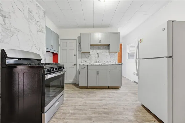 a kitchen with stainless steel appliances granite countertop a stove a refrigerator and a sink