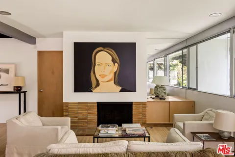a living room with furniture a fireplace and a large window