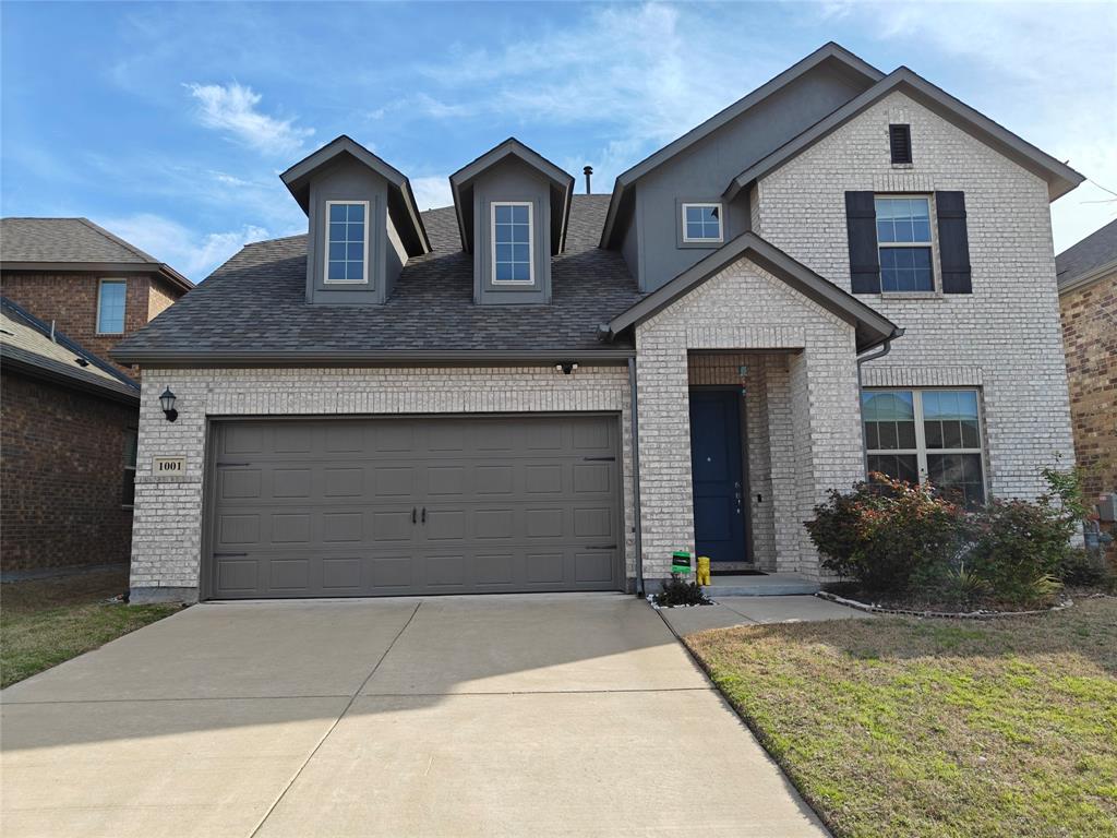 View of front facade with driveway, brick siding, a garage, and a shingled roof