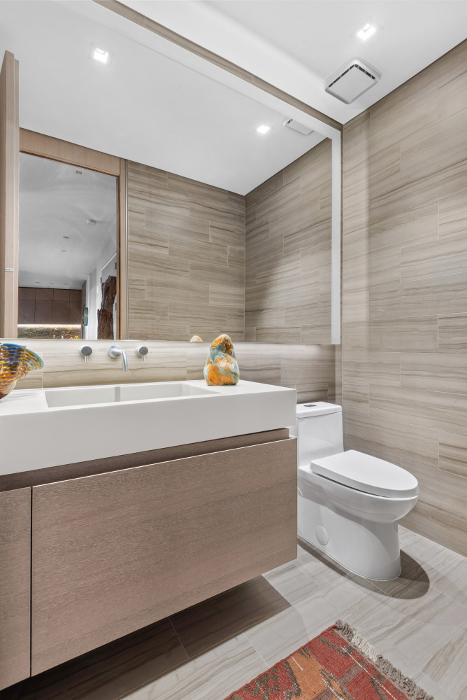 49 Chambers Street, Unit 8F Manhattan, NY 10007 - Photo 8 of 9 a bathroom with a sink a toilet and mirror