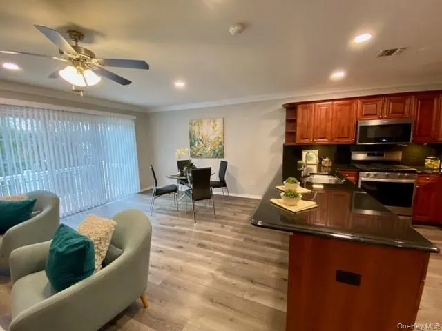 a view of a dining room with furniture a kitchen and chandelier