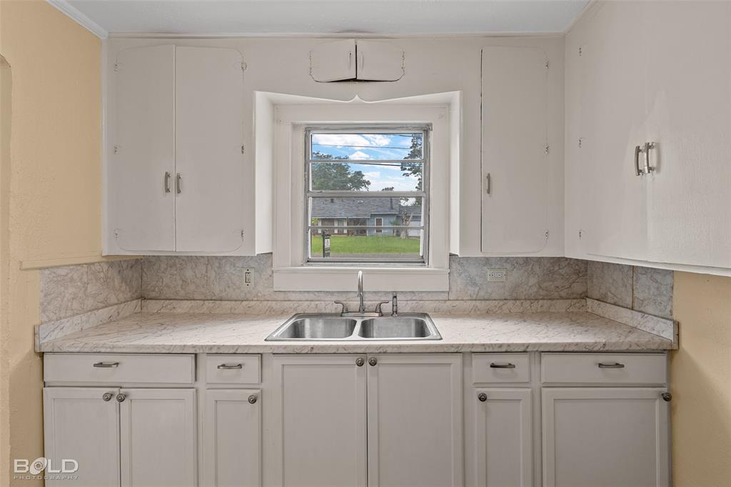 115 Pam Street Mansfield, LA 71052 - Photo 12 of 25 a kitchen with stainless steel appliances granite countertop a sink a window and cabinets
