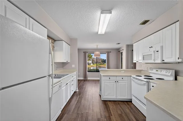 a kitchen with white cabinets stainless steel appliances and sink