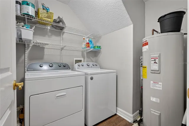 an aerial view of a house with swimming pool and large trees