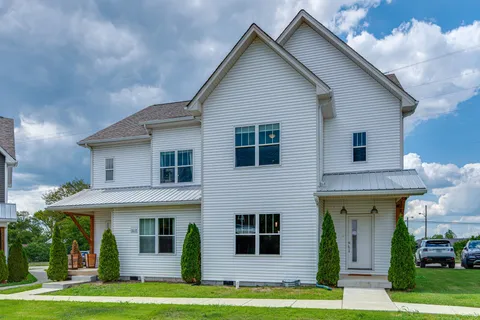 a front view of a house with a garden and plants