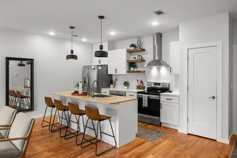 a kitchen with stainless steel appliances a stove a refrigerator and a counter space