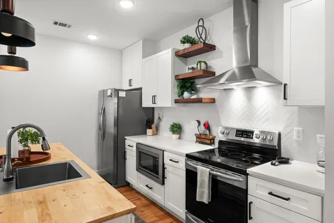 a kitchen with stainless steel appliances granite countertop a sink and a refrigerator