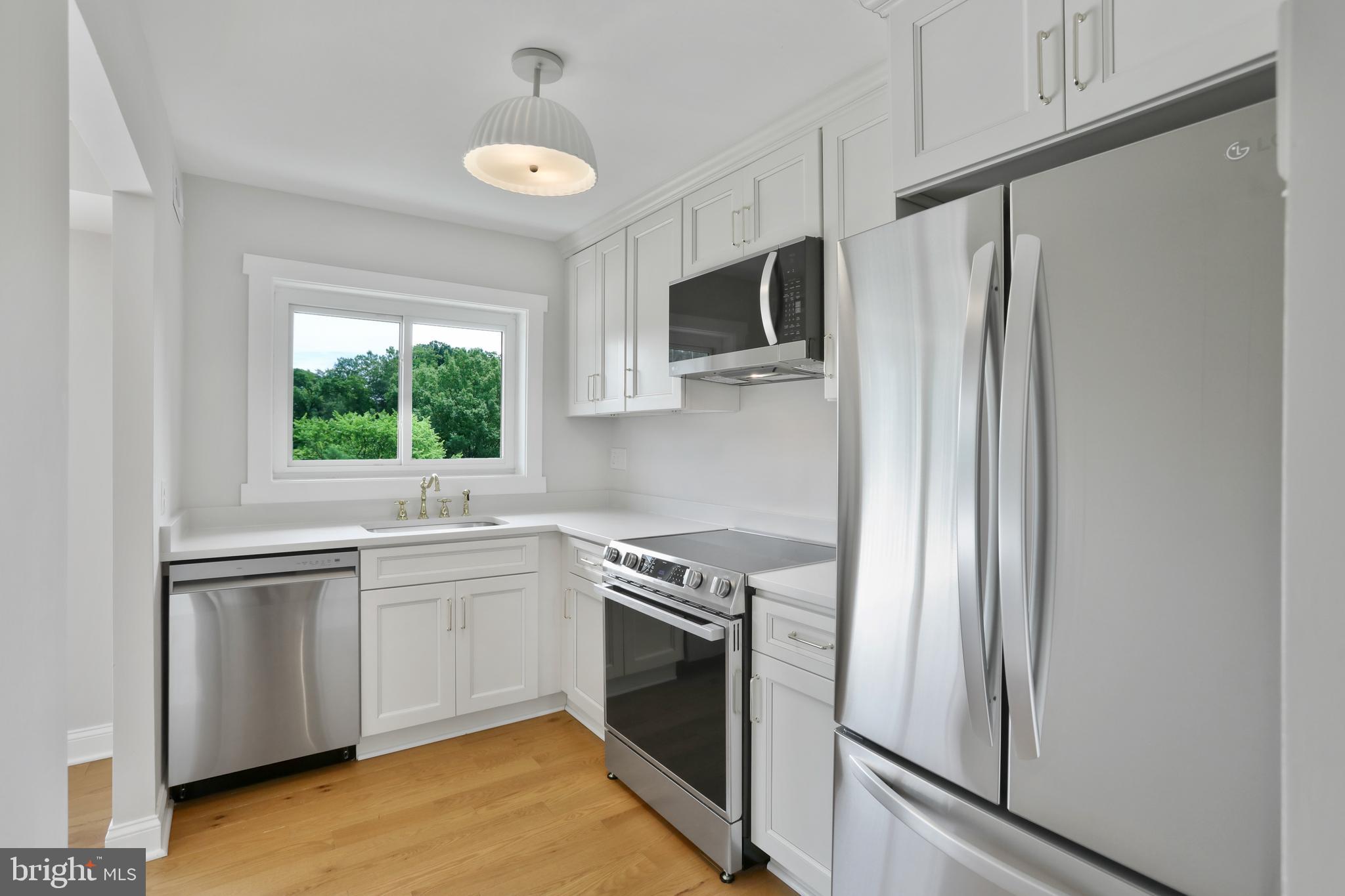 a kitchen with stainless steel appliances granite countertop a refrigerator sink and stove