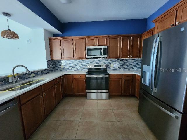2801 South Ridgewood Avenue, Unit 403 South Daytona, FL 32119 - Photo 3 of 16 a kitchen with stainless steel appliances granite countertop a stove top oven a sink and dishwasher