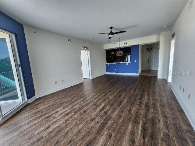 2801 South Ridgewood Avenue, Unit 403 South Daytona, FL 32119 - Photo 5 of 16 a view of a livingroom with wooden floor and a ceiling fan