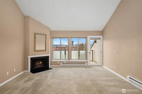 an empty room with floor to ceiling window and fireplace