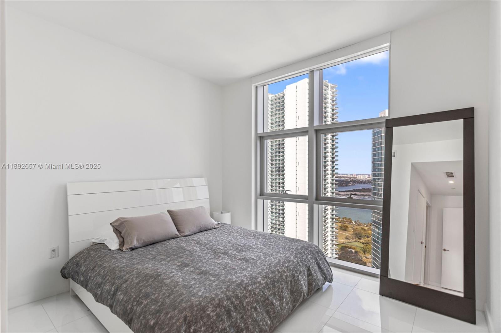 851 Northeast 1st Avenue, Unit 3707 Miami, FL 33132 - Photo 17 of 28 a bedroom with a large bed and a large window
