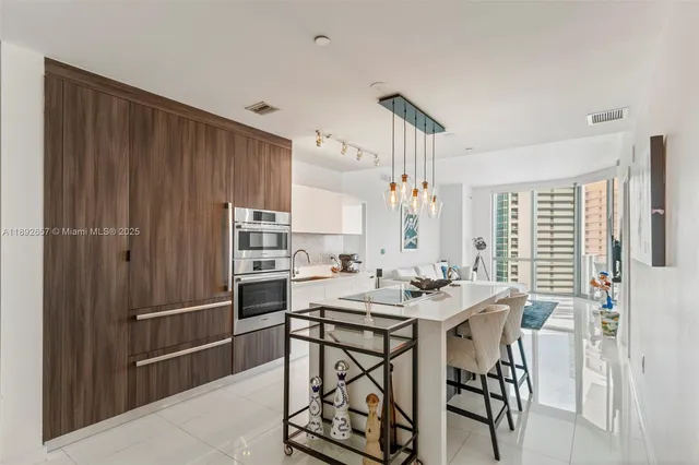 a kitchen with stainless steel appliances a table and chairs in it