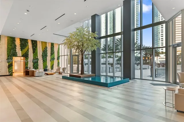 a view of an entryway with floor to ceiling windows and wooden floor