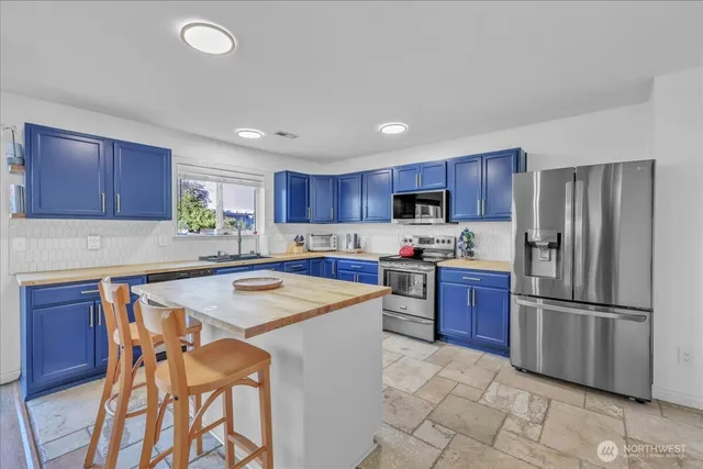 a kitchen with stainless steel appliances granite countertop a refrigerator sink and cabinets