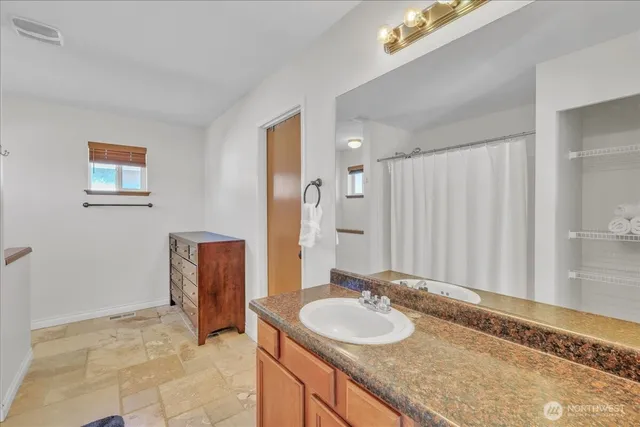 a bathroom with a granite countertop sink and a mirror