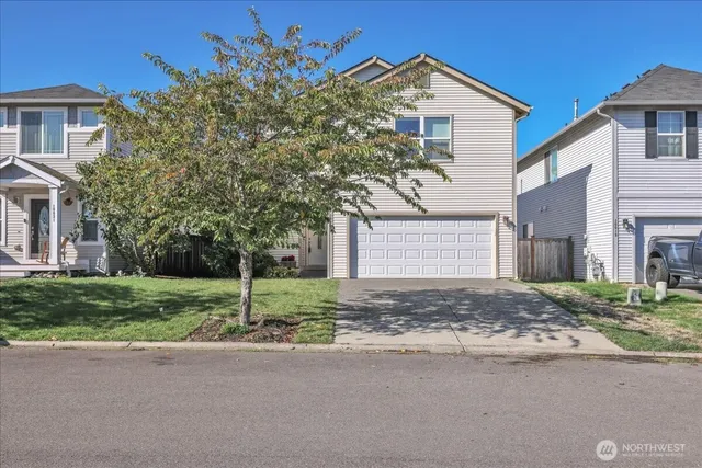 a front view of a house with a yard and garage