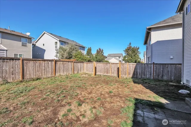 a view of a house with a yard and wooden fence
