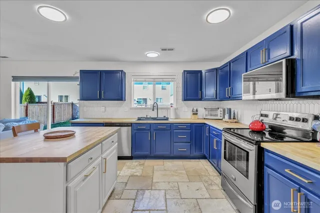 a kitchen with stainless steel appliances granite countertop a sink stove microwave and cabinets