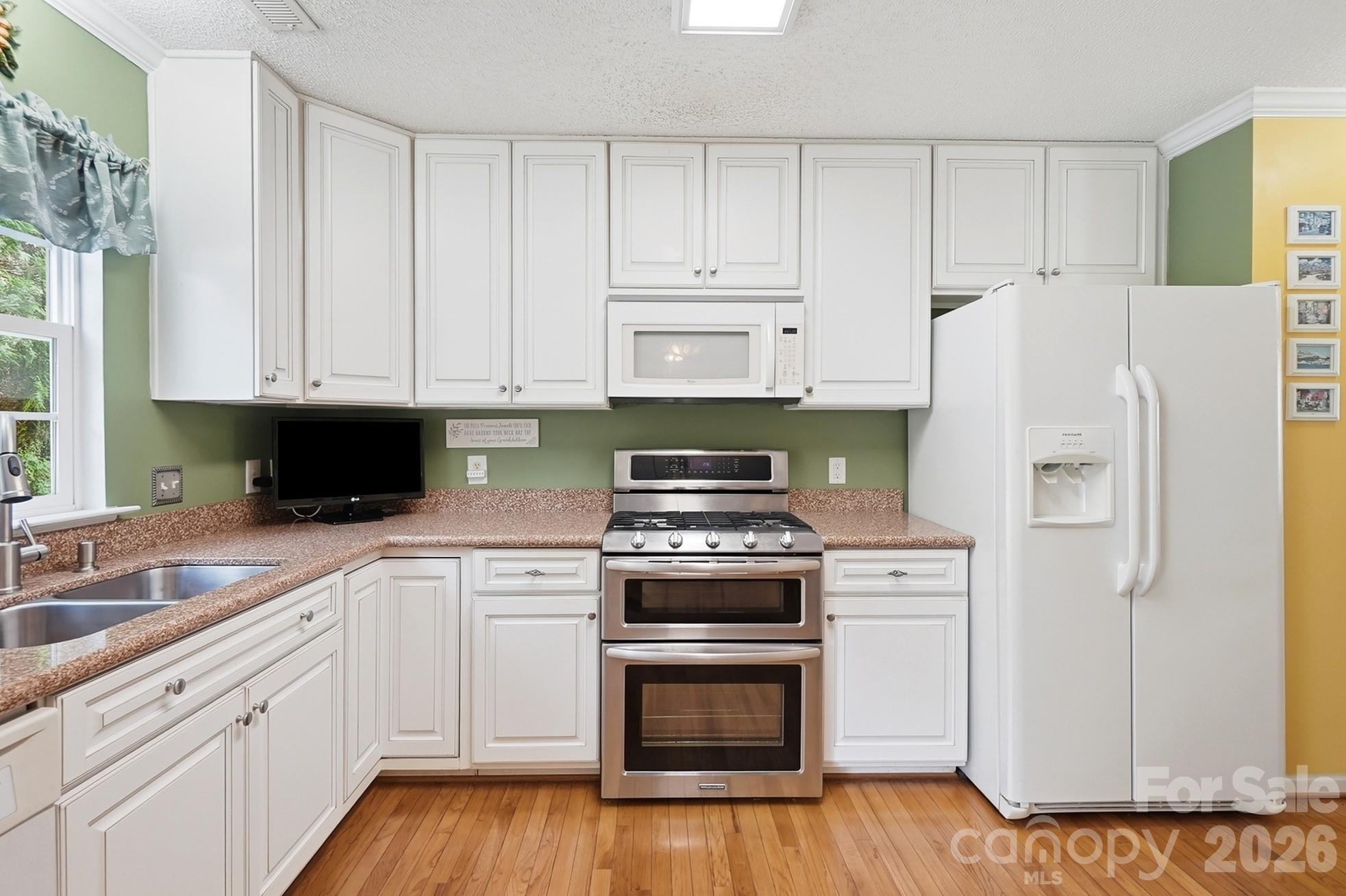 442 Sugar Maple Drive Tega Cay, SC 29708 - Photo 10 of 48 a kitchen with granite countertop white cabinets and stainless steel appliances
