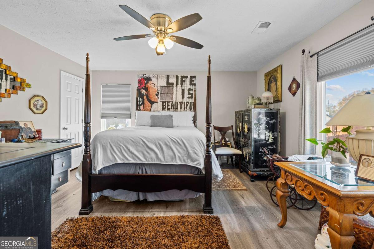 6324 Amberly Road Rex, GA 30273 - Photo 20 of 22 a bedroom with a bed a dresser and painting on the wall