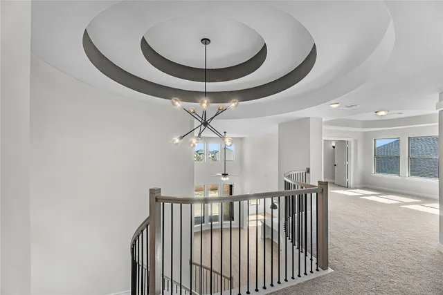 a view of a hallway with a chandelier and front door