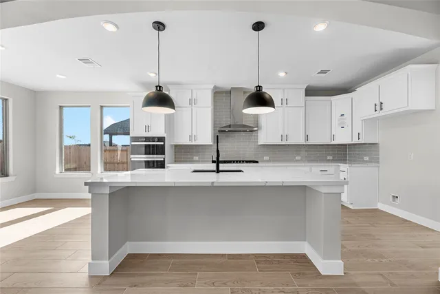 a kitchen with kitchen island a counter top space a sink and cabinets