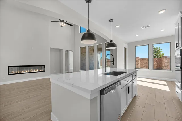 a kitchen with granite countertop a sink a counter top space and living room view
