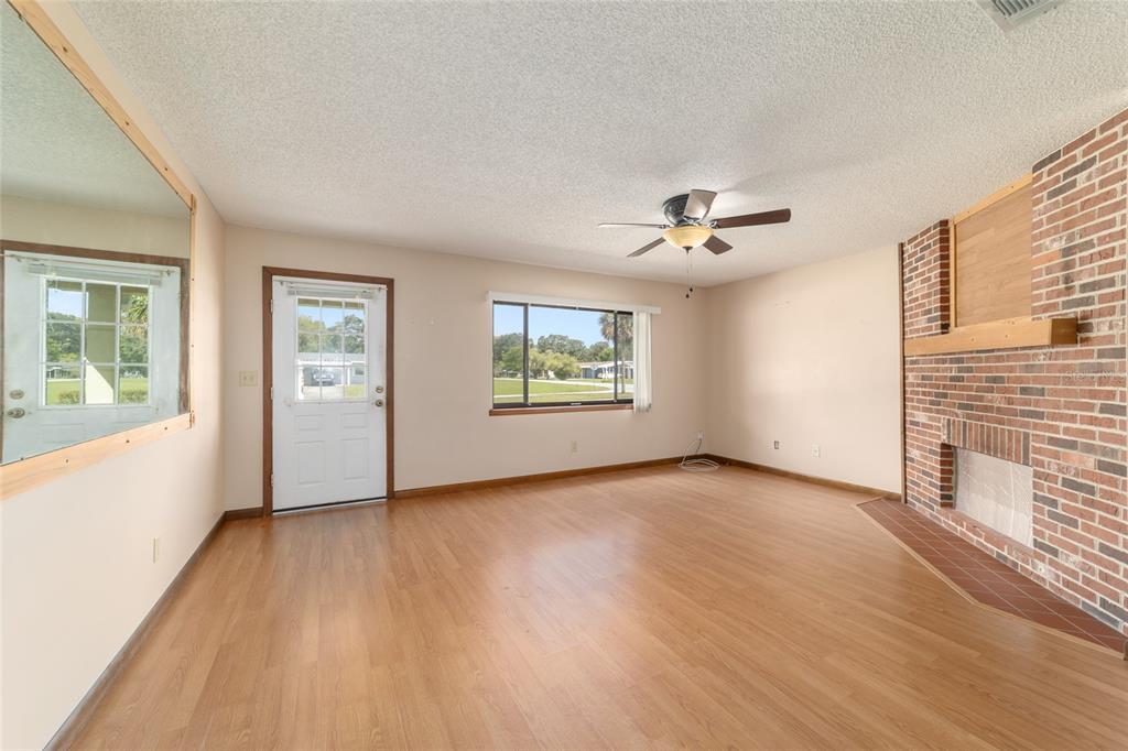 8954 Southwest 101st Place Ocala, FL 34481 - Photo 7 of 42 a view of an empty room with a window and wooden floor