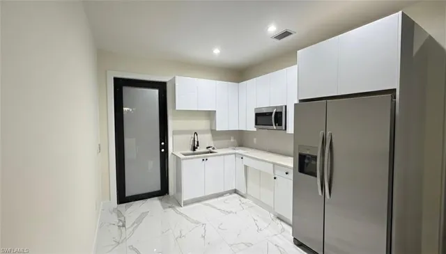 a kitchen with stainless steel appliances a refrigerator sink and stove