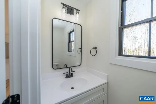 a bathroom with a sink and mirror with window