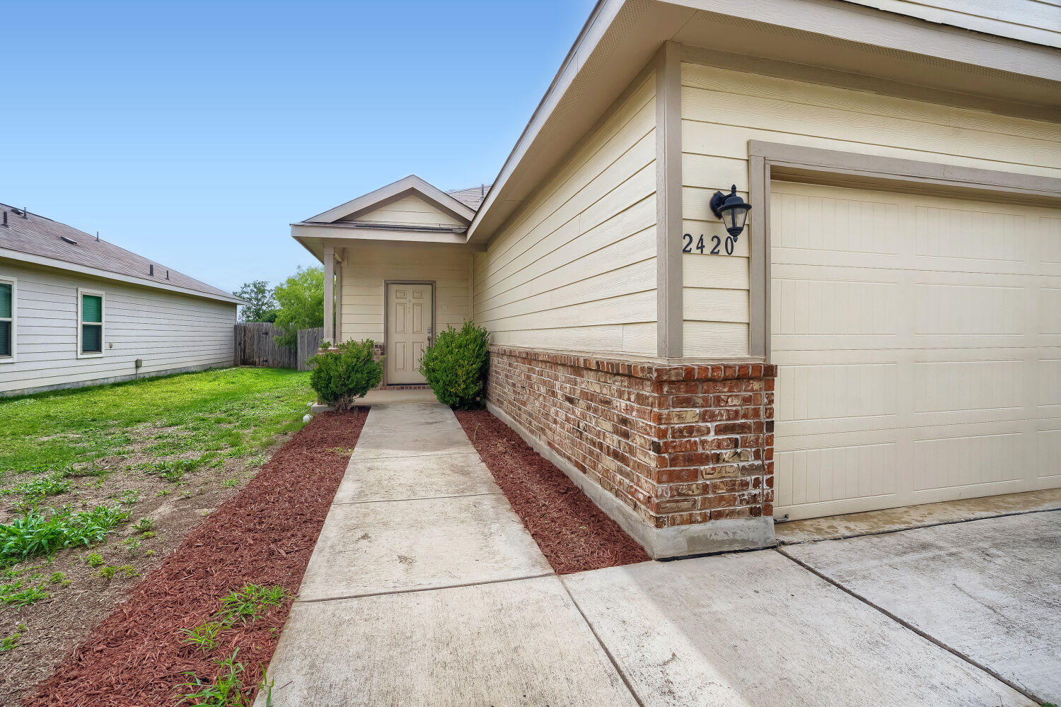 2420 Ranger Pass Seguin, TX 78155 - Photo 3 of 28 Exterior facade featuring horizontal siding, a brick accent wall, and an attached garage with a panel door