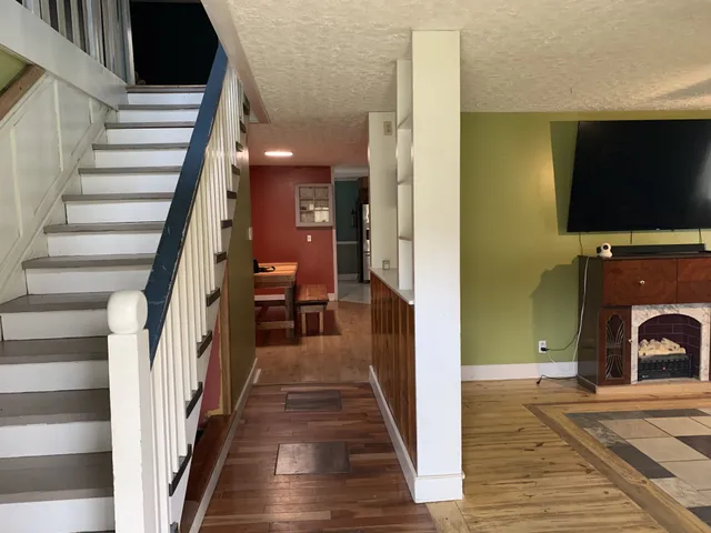 a view of a livingroom with furniture fire place and wooden floor